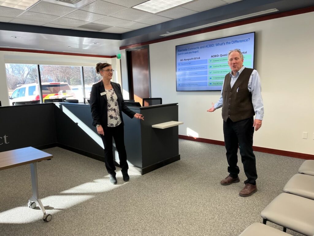 Woman and man presenting together in front screen in a conference room